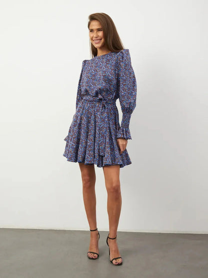 Azure Bloom Mini Dress featuring vibrant blue florals, flowing silhouette, and elegant ruffled details.