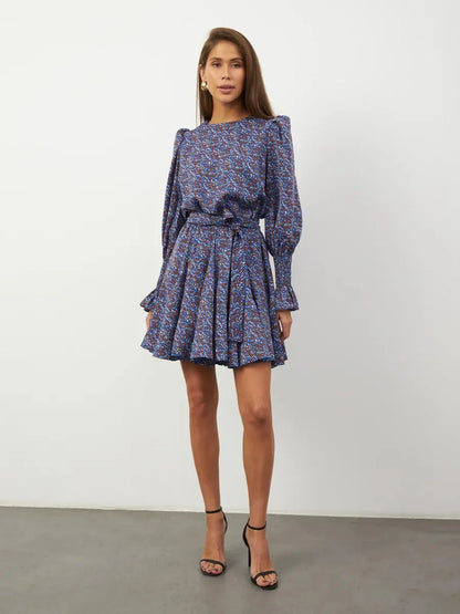 Azure Bloom Mini Dress featuring vibrant blue floral patterns, long sleeves, and a feminine silhouette.