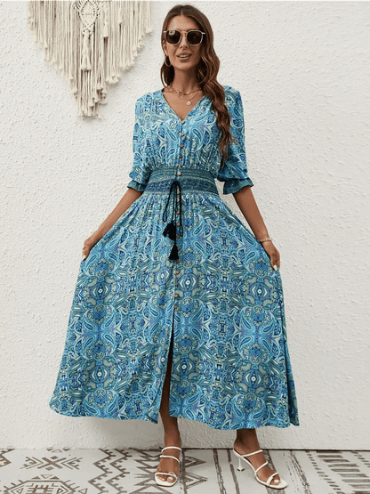 Woman wearing an Azure Drift Maxi Dress featuring a paisley print and smocked waist, perfect for summer occasions.