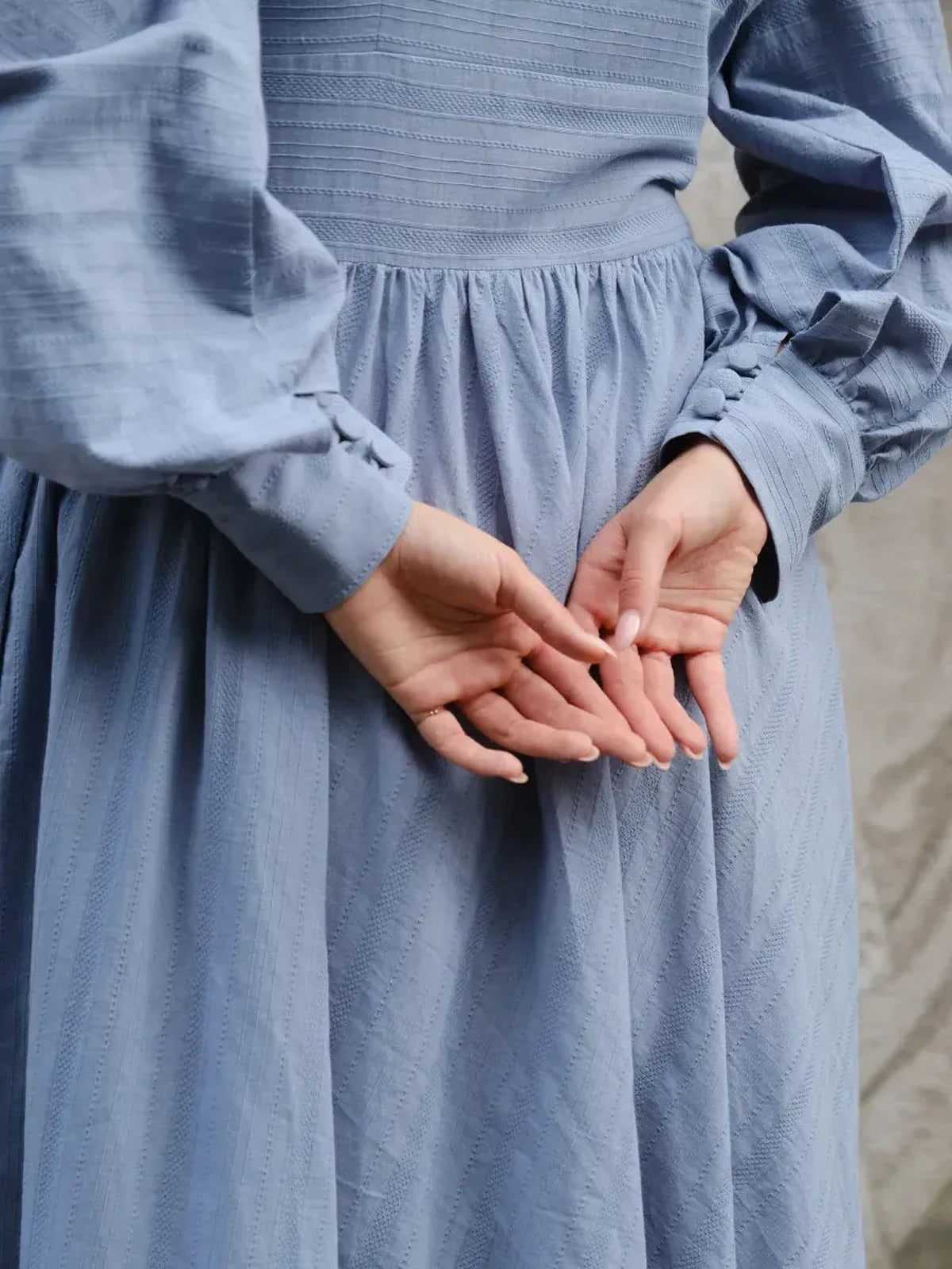 Detail view of Azure Grace Maxi Dress in light blue, showcasing elegant sleeves and cinched waist.