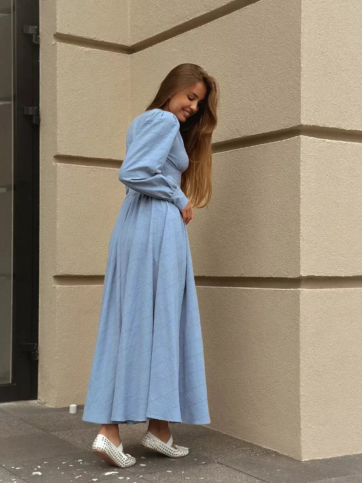 Woman in light blue Azure Grace Maxi Dress with button detail and flowy silhouette, showcasing a chic summer style.