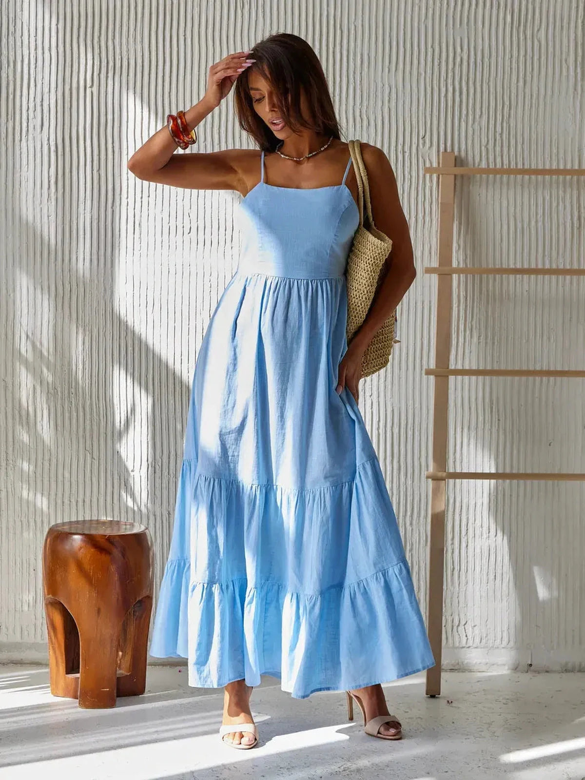 Azure Muse Maxi Dress in sky-blue with tiered skirt, perfect for summer outings, showcasing a backless design and effortless style.