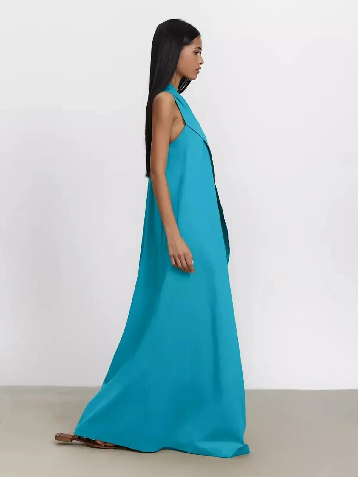 Model wearing the Azure Sway Maxi Dress in vibrant turquoise, showcasing its elegant one-shoulder design and flowy silhouette.