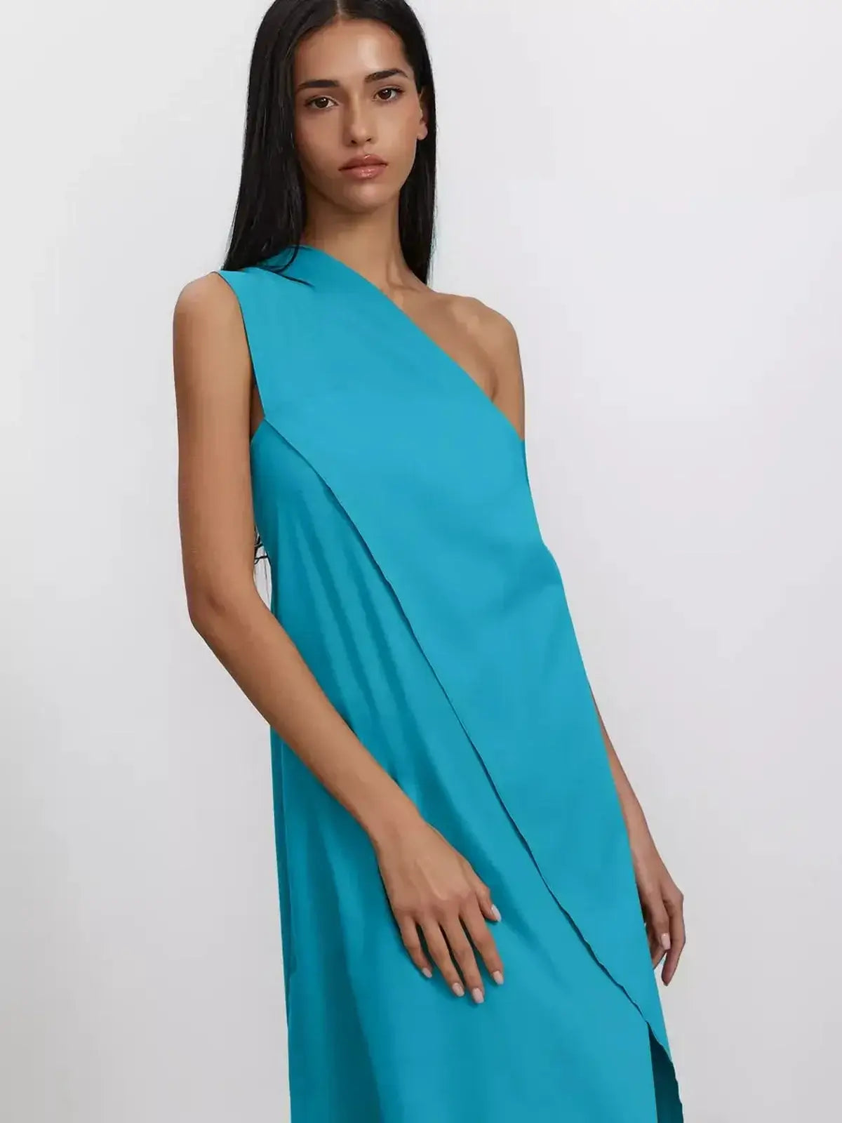 Model wearing the Azure Sway Maxi Dress in a vibrant turquoise, showcasing its one-shoulder design and A-line silhouette.
