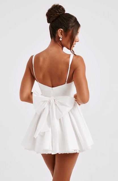 Back view of a white Barbie mini dress featuring a corset bodice and a large bow, perfect for summer parties and weddings.