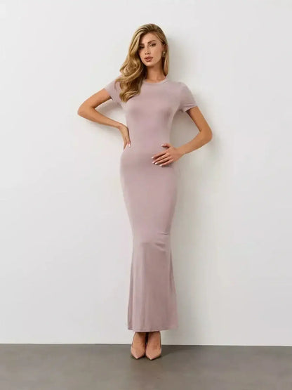 Elegant model wearing the Bare Essence Maxi Dress by Lauven in a soft beige tone with a flared hem.