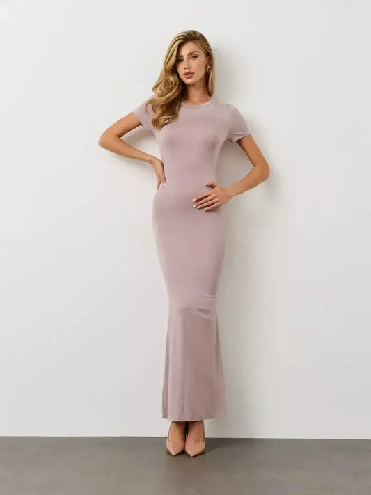 Elegant model wearing the Bare Essence Maxi Dress by Lauven in a soft beige tone with a flared hem.