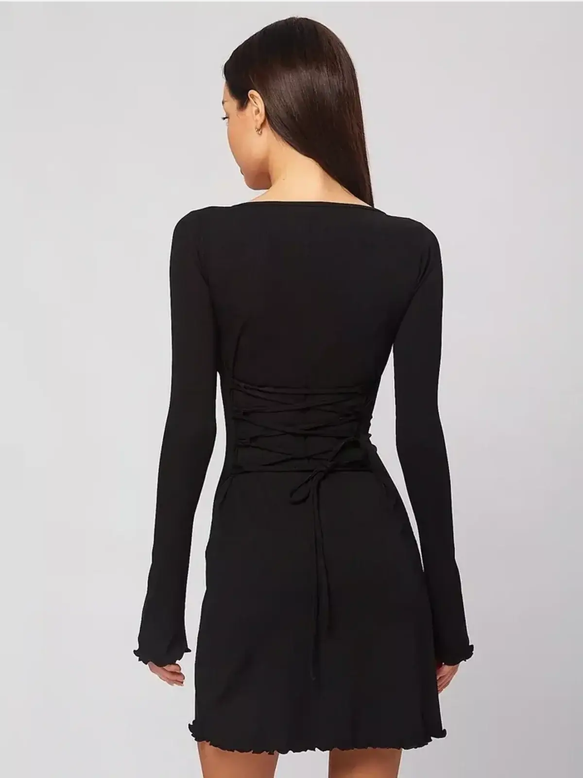 Back view of a sculpting black mini dress with lace-up detail and long sleeves, perfect for summer or formal occasions.