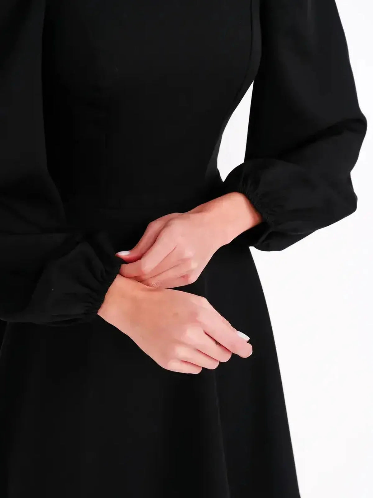 Close-up of black mini dress featuring a sculpted bodice and voluminous puff sleeves.