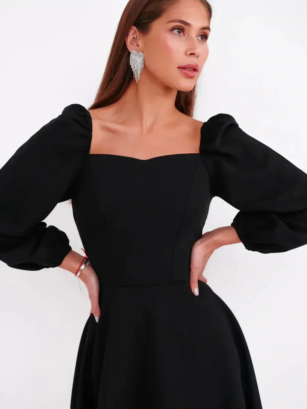 Model wearing a black mini dress with a sculpted bodice and voluminous long sleeves, perfect for weddings and parties.