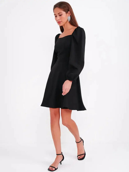 Black mini dress with a sculpted bodice, puff sleeves, and A-line skirt, perfect for weddings and parties.
