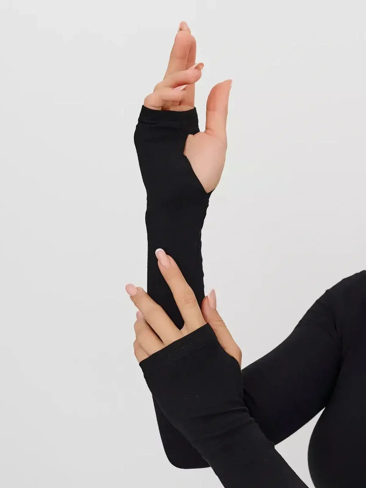 Close-up of long sleeves with thumbholes from a sleek black Zip Form Mini Dress for women.