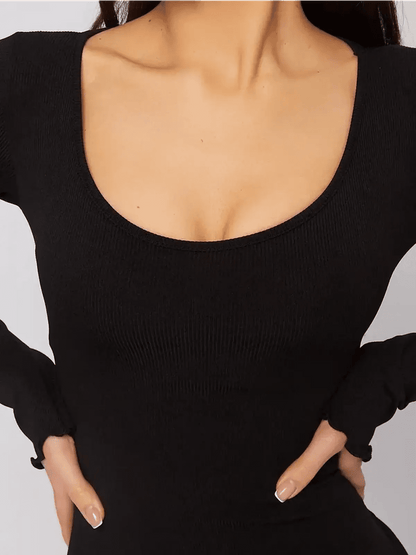 Close-up of a black mini dress with a U-shaped neckline and long sleeves, showcasing a body-hugging silhouette.