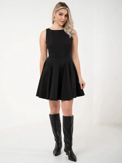 Elegant black mini dress with a flared skirt, styled with knee-high boots for a chic look.