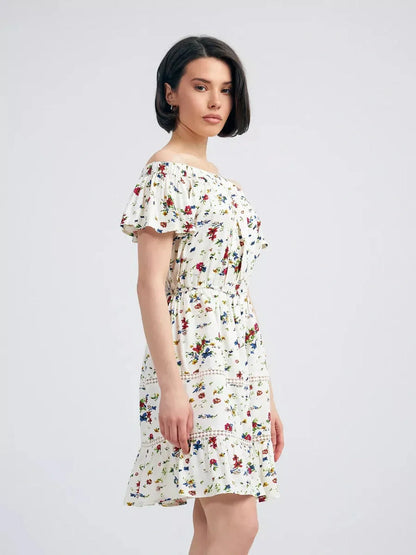 Model wearing the Bloom Off-Shoulder dress featuring a floral print and relaxed fit perfect for summer elegance.