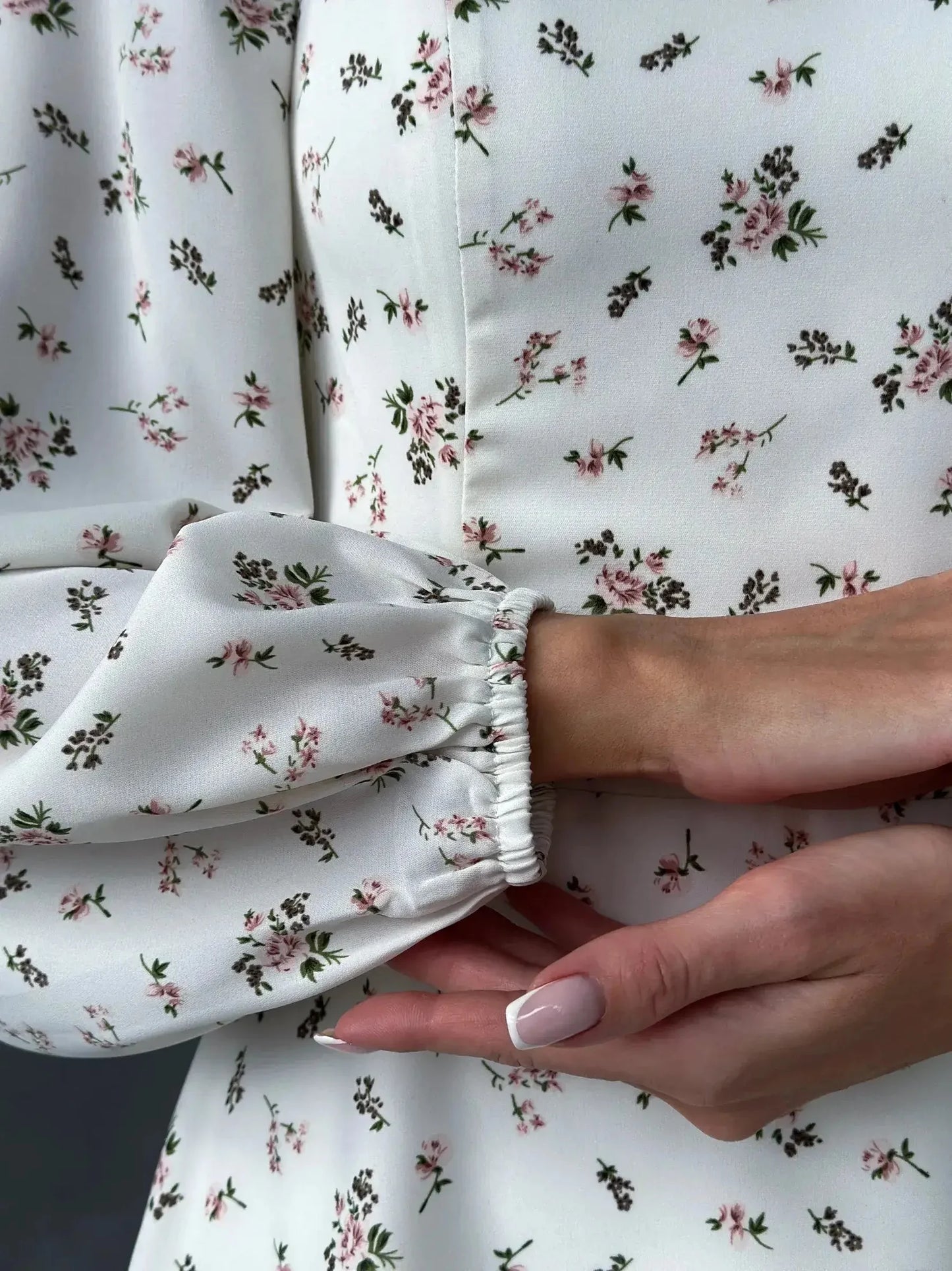 Close-up of the Blossom Grace dress featuring delicate floral print and puffed sleeves for a refined summer style.