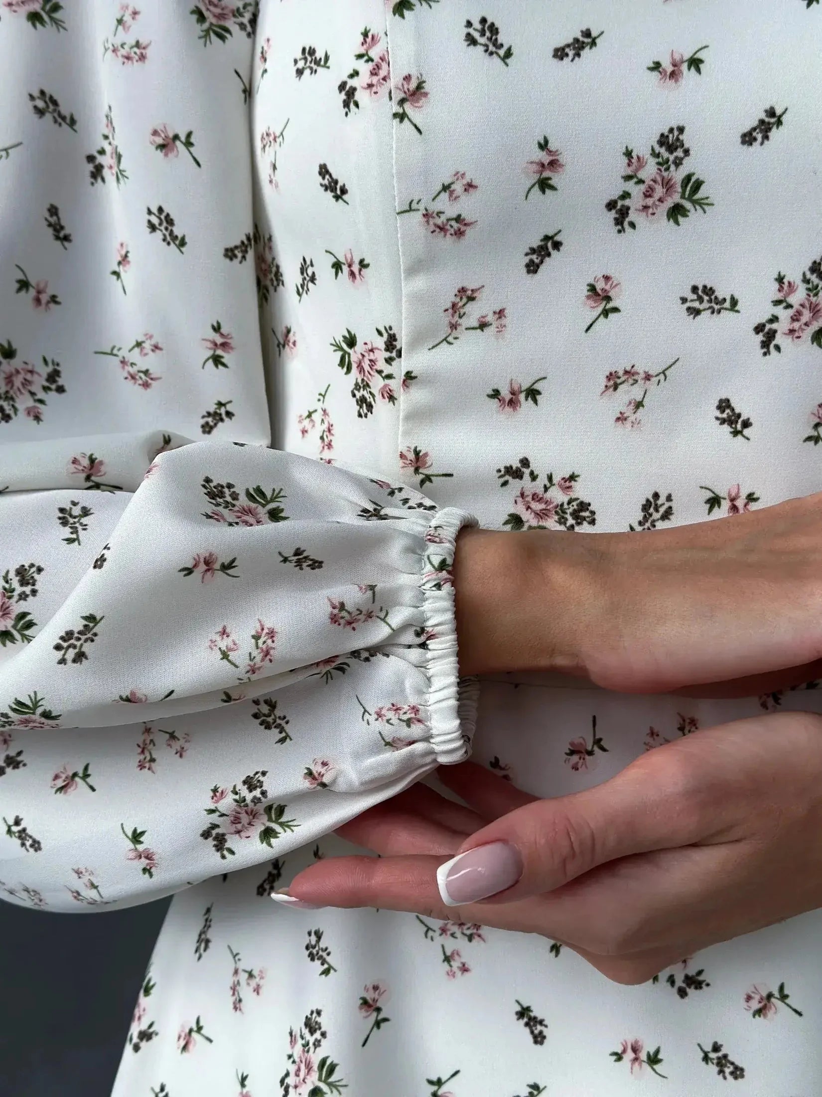 Close-up of the Blossom Grace dress featuring delicate floral print and puffed sleeves for a refined summer style.