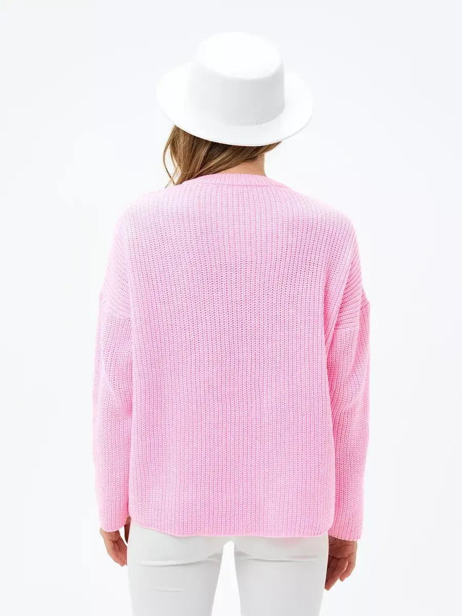 Back view of the Blossom Sweater by Lauven in soft pink, showcasing its oversized knit design.