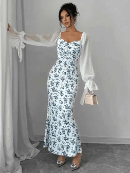Model showcasing the Bluebelle Maxi Dress with floral design and sheer sleeves, embodying elegance and femininity.