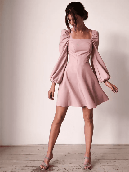 Elegant Blush Aura mini dress featuring puff sleeves, square neckline, and flared skirt, perfect for weddings and celebrations.