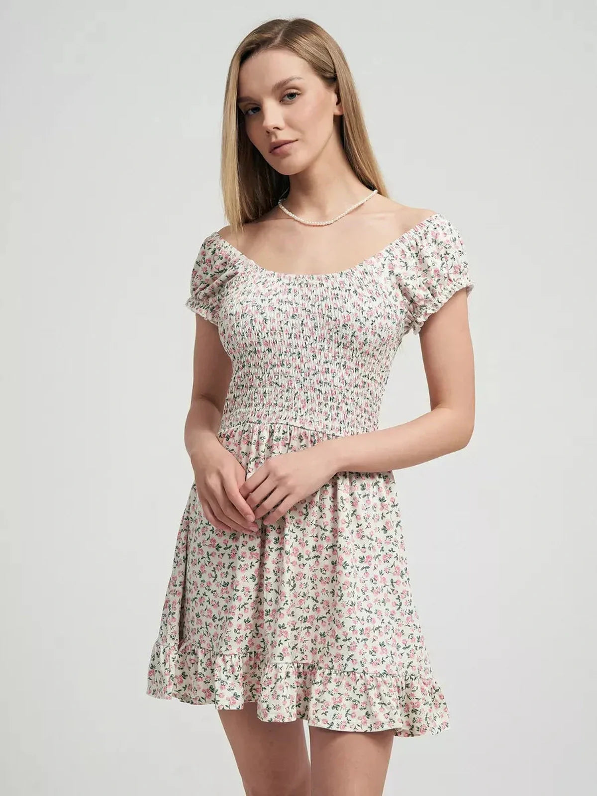 Model wearing the Blush Blossom summer dress with pink floral prints and a ruffled hem, ideal for romantic occasions.