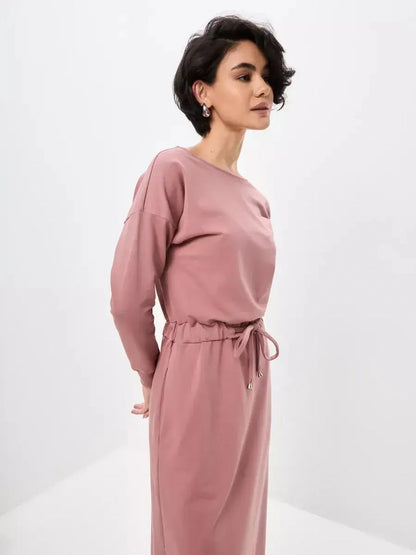 Elegant woman modeling a dusty pink Blush Lounge Maxi Dress featuring a boat neckline and drawstring waist.