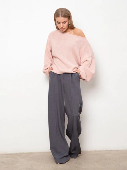Model wearing a Blush Sweater by Lauven with oversized fit and boat neck, paired with wide-leg trousers.