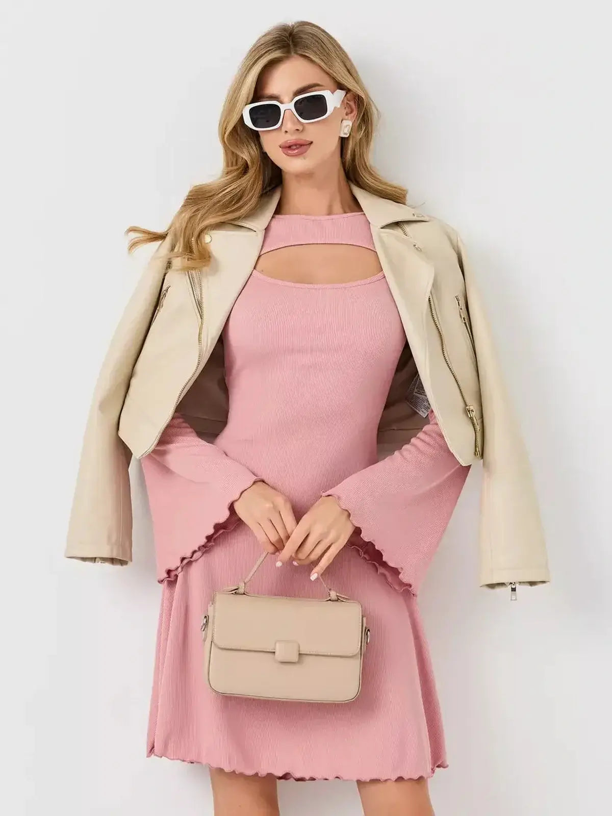 Model wearing the Blush Whisper dress by Lauven, featuring a U-neckline and flared sleeves, styled with a leather jacket.