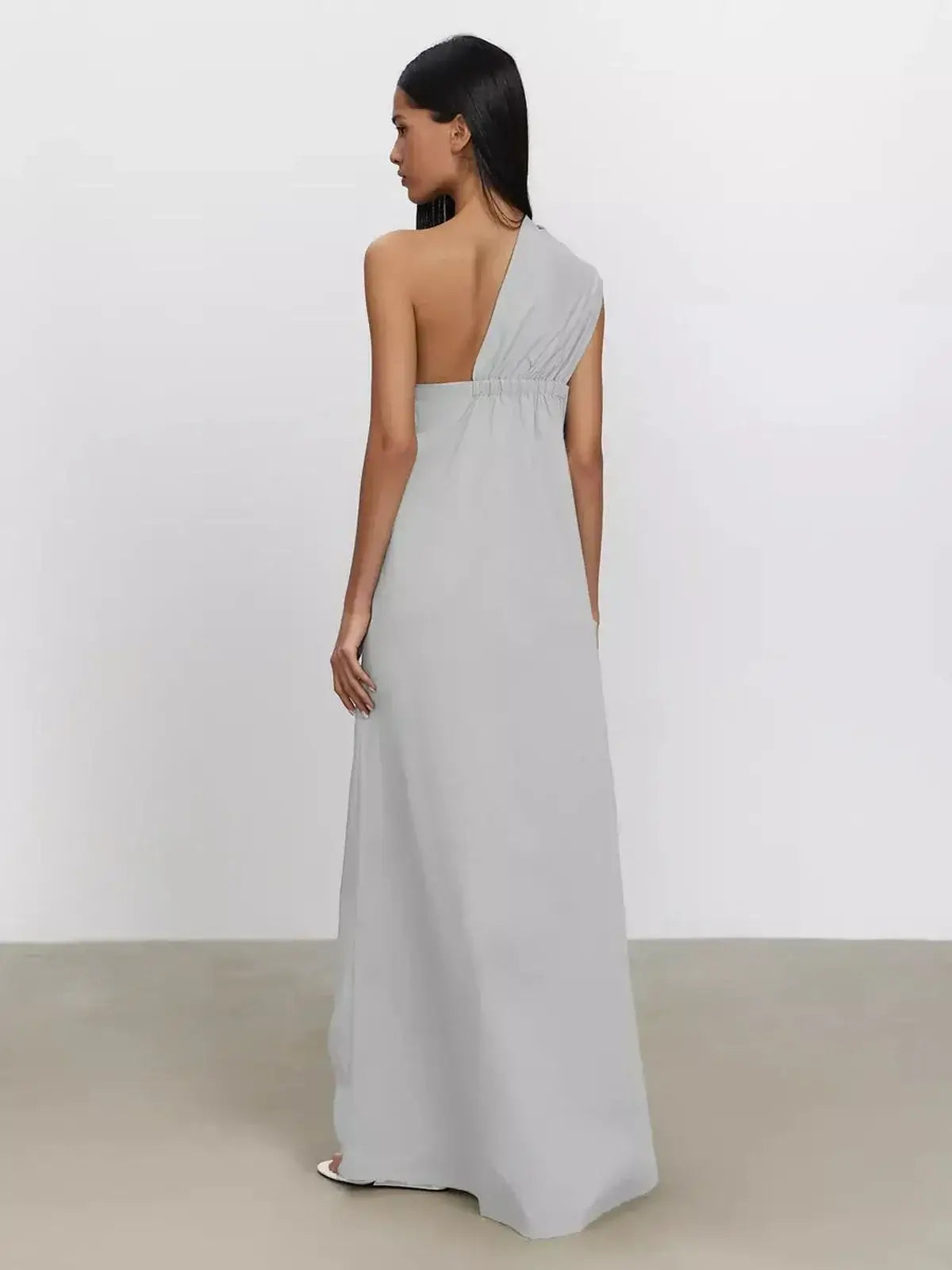 Elegant Cascade Maxi Dress in soft gray with one-shoulder design and flowing A-line silhouette, showcasing comfort and style.