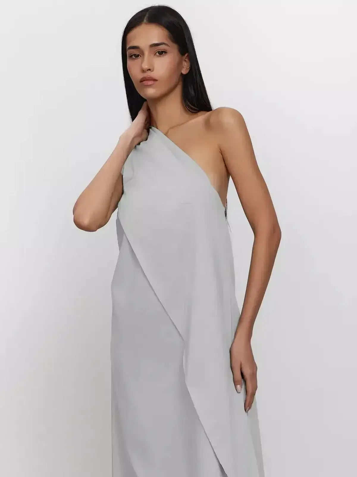 Model wearing a light gray one-shoulder Cascade Maxi Dress made from breathable cotton, showcasing elegant A-line silhouette.