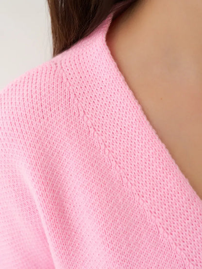 Close-up of the Celeste Cardigan by Lauven, featuring a soft pink knit fabric and refined neckline.