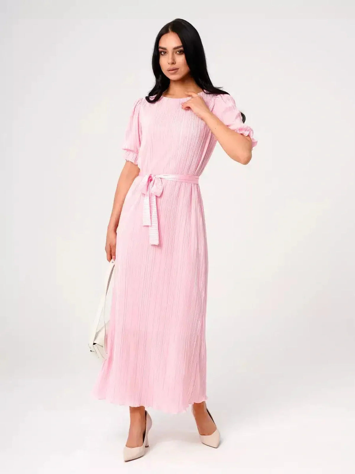 Celeste Maxi Dress in soft pink, featuring pleated fabric, puff sleeves, and a tie waist for an elegant look.