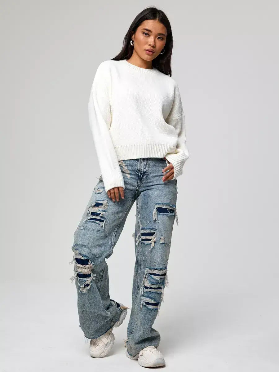 Model wearing Celeste Pullover by Lauven, an oversized cropped women's sweater, paired with distressed jeans.