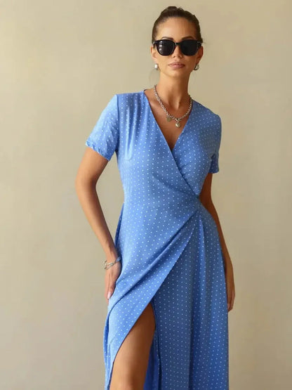 Celeste Wrap Maxi Dress in soft blue with polka dots, featuring a V-neck, wrap silhouette, and thigh-high slit.