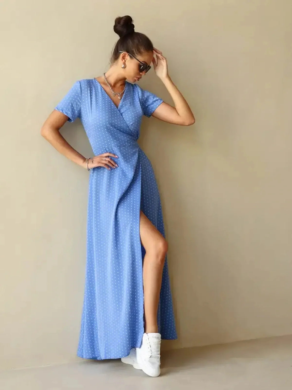 Celeste Wrap Maxi Dress in soft blue polka dot fabric featuring a flattering V-neckline and thigh-high slit.
