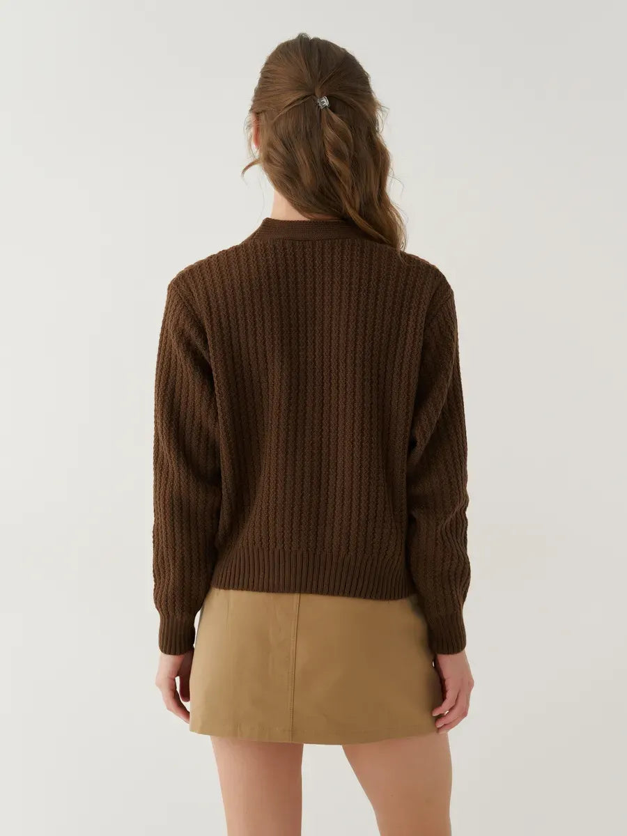 Back view of a woman wearing the Chestnut Cardigan, an oversized cropped knitwear piece by Lauven, in warm brown.