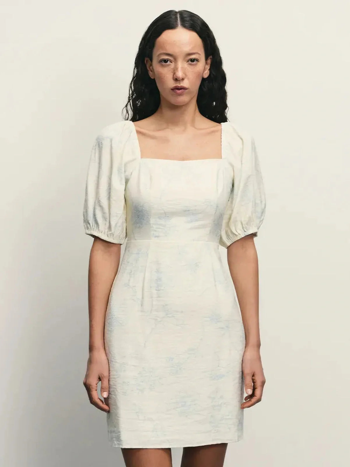 Cloud Bloom elegant white mini dress with square neckline and puff sleeves, featuring a delicate pale blue floral pattern.