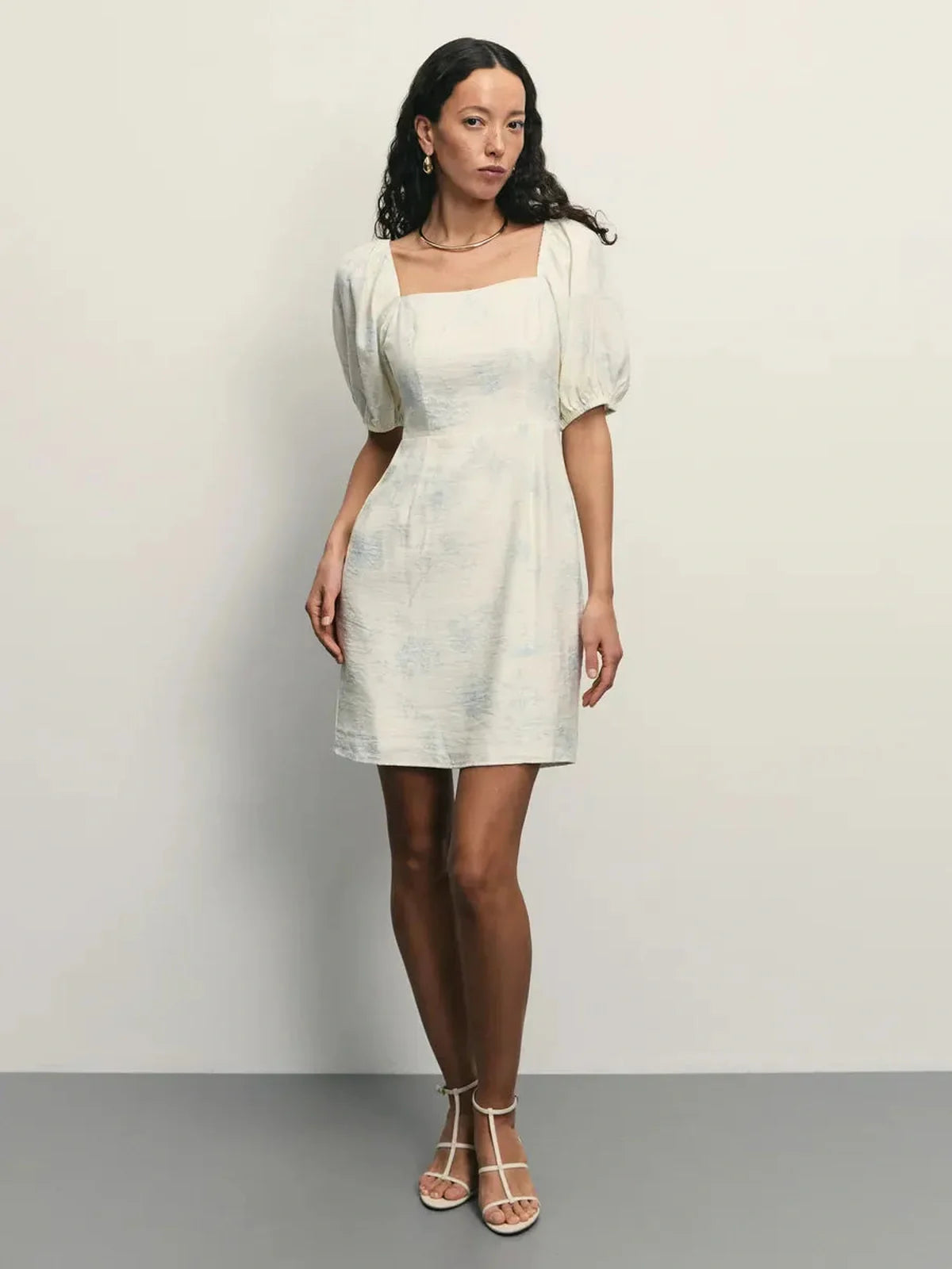 Elegant white Cloud Bloom mini dress with puff sleeves and square neckline, featuring pale blue floral pattern.