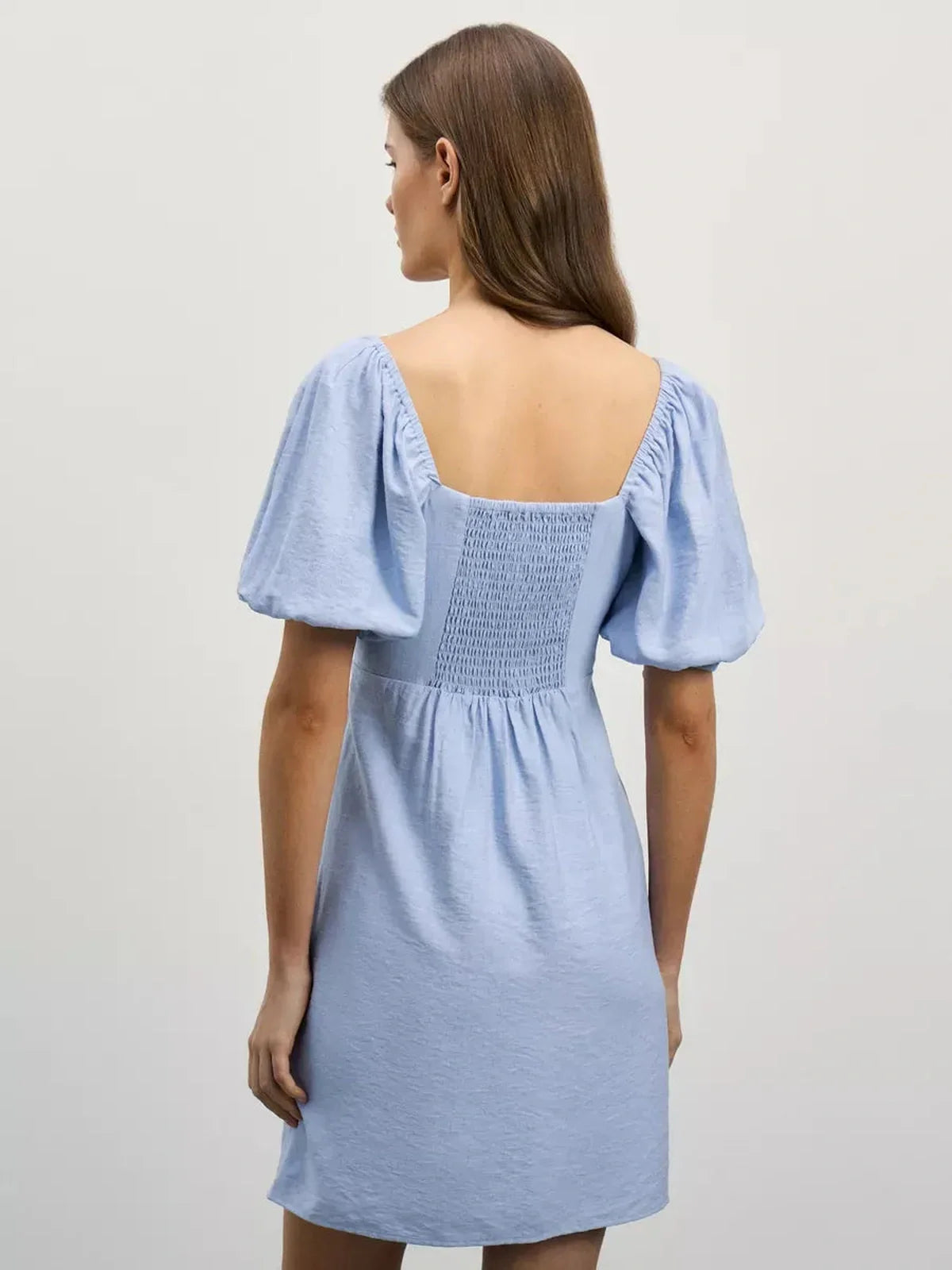 Back view of the Cloudline Mini summer dress, featuring a square neckline and short puff sleeves in light blue.