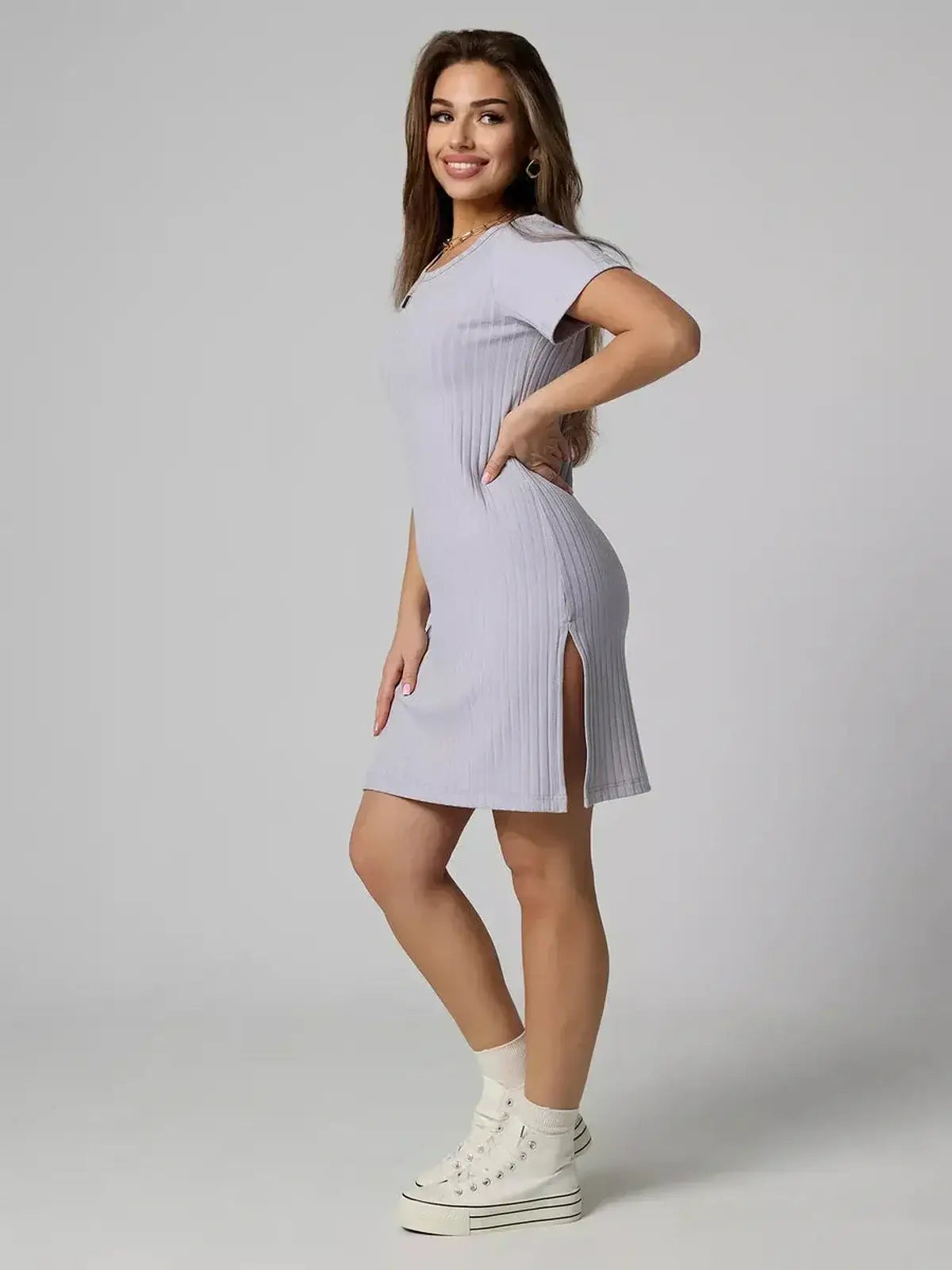 Model wears the Cloudline Mini ribbed summer dress by Lauven, showcasing its sleek silhouette and stylish side slit.