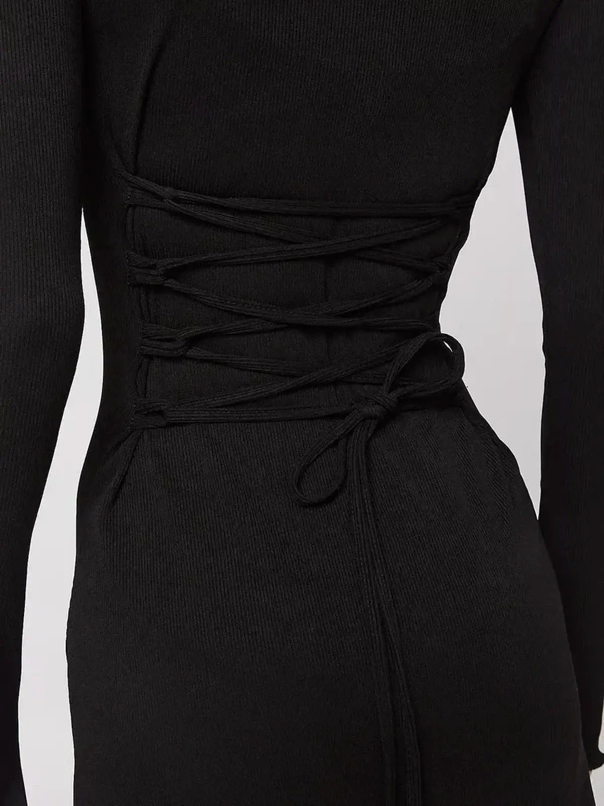 Black mini dress with lace-up back detail, showcasing a body-hugging silhouette and long sleeves.