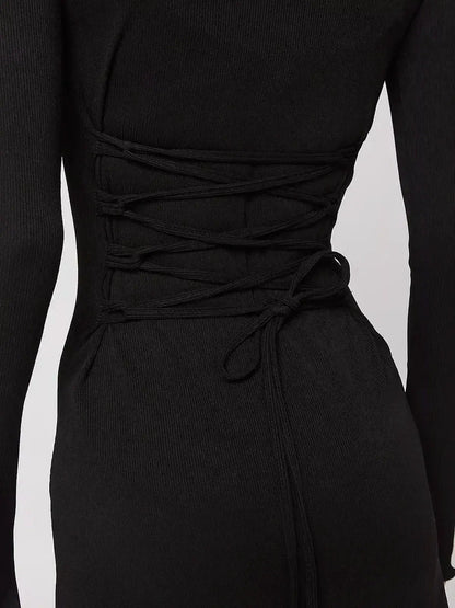 Black mini dress with lace-up back detail, showcasing a body-hugging silhouette and long sleeves.