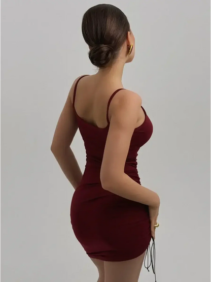 Back view of a model wearing the Crimson Aura Dress in deep burgundy, featuring spaghetti straps and side ruching.