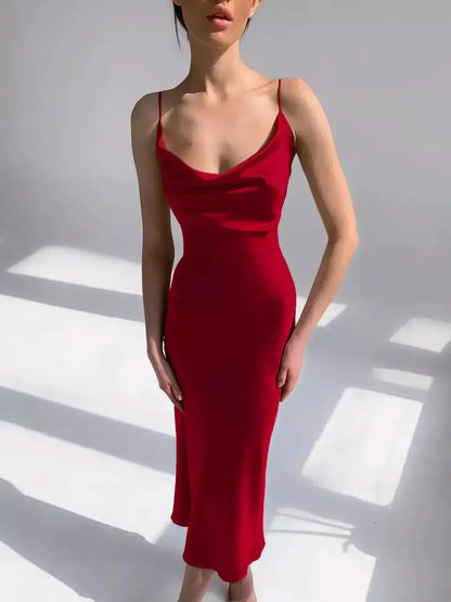 Sleek crimson midi dress with a cowl neckline and spaghetti straps, showcasing a sultry silhouette and elegant satin fabric.