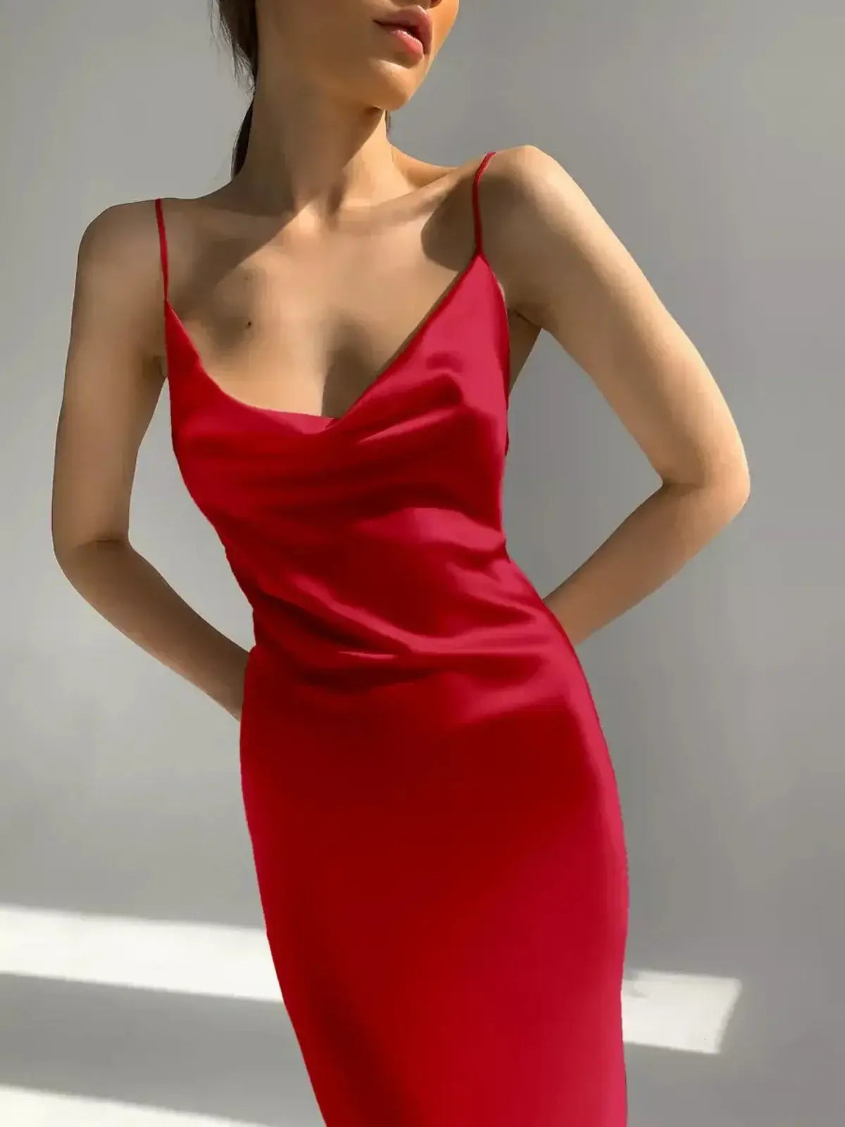 Model showcasing the sleek and sultry Crimson Muse Midi Dress with a satin finish and elegant drape.