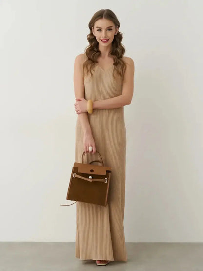 Woman in a beige ribbed Desert Aura Maxi Dress holding a brown handbag, showcasing summer elegance and effortless style.
