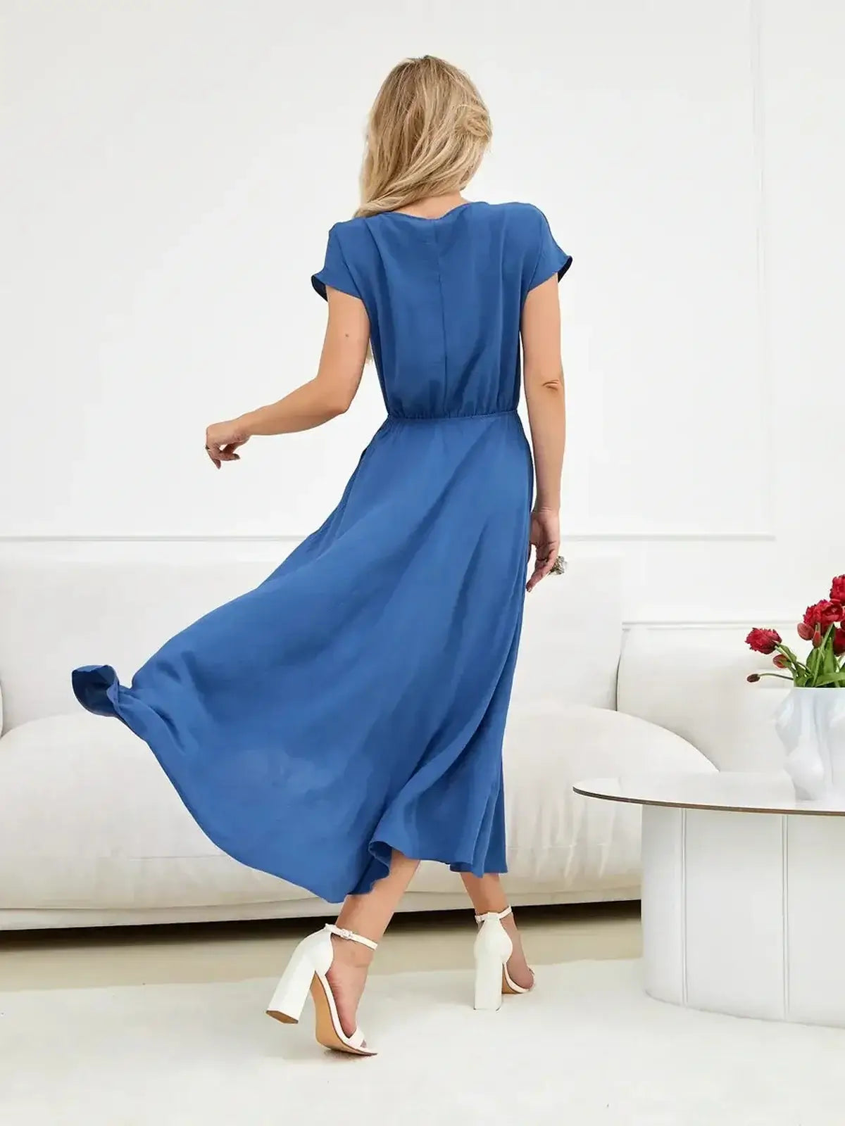 Woman wearing a Drift Maxi Dress in blue, featuring a relaxed fit and flowing silhouette, perfect for summer occasions.
