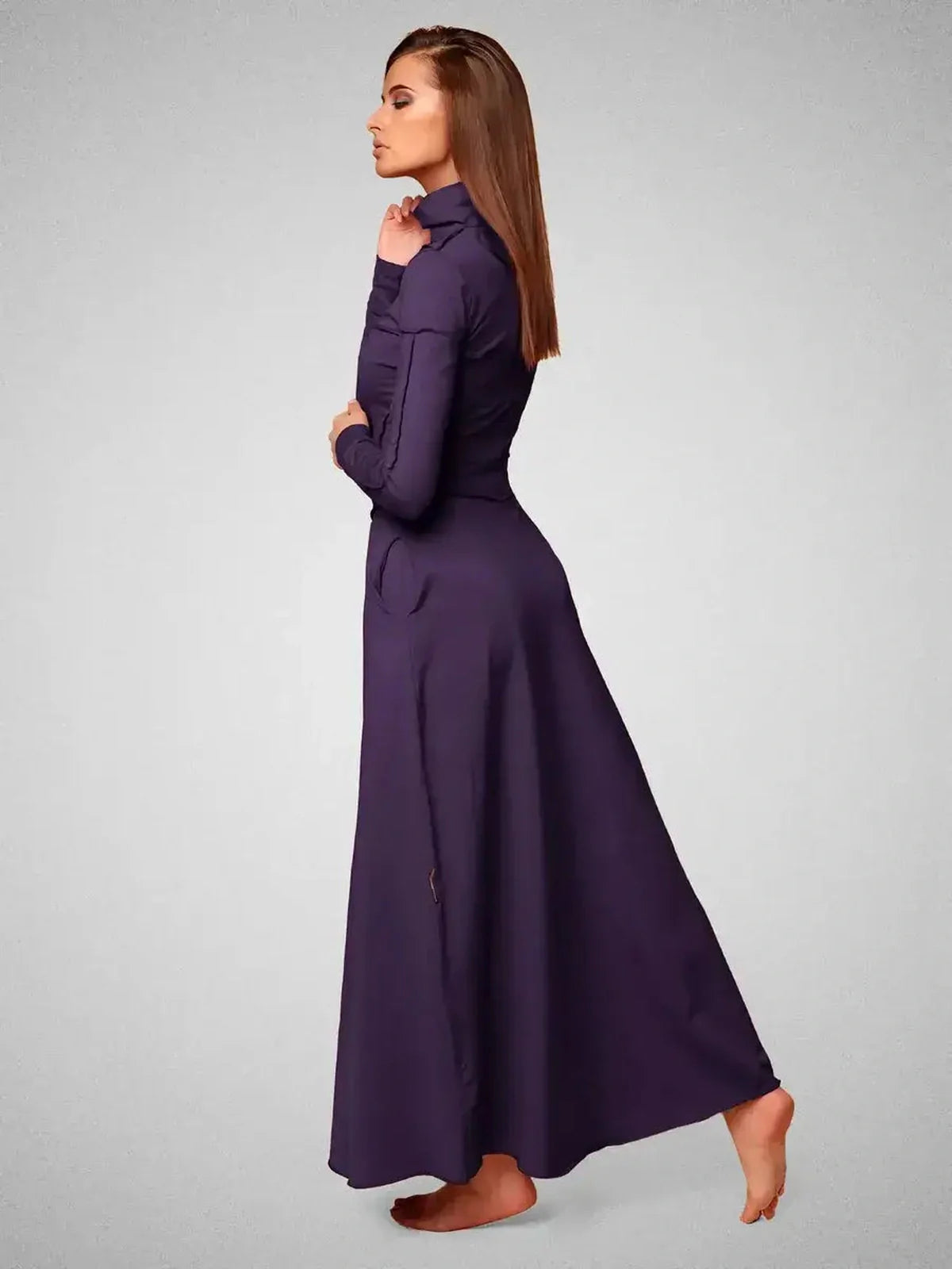 Side view of a model wearing the Eclipse Maxi Dress in dark violet, showcasing its elegant seam detailing and flattering silhouette.