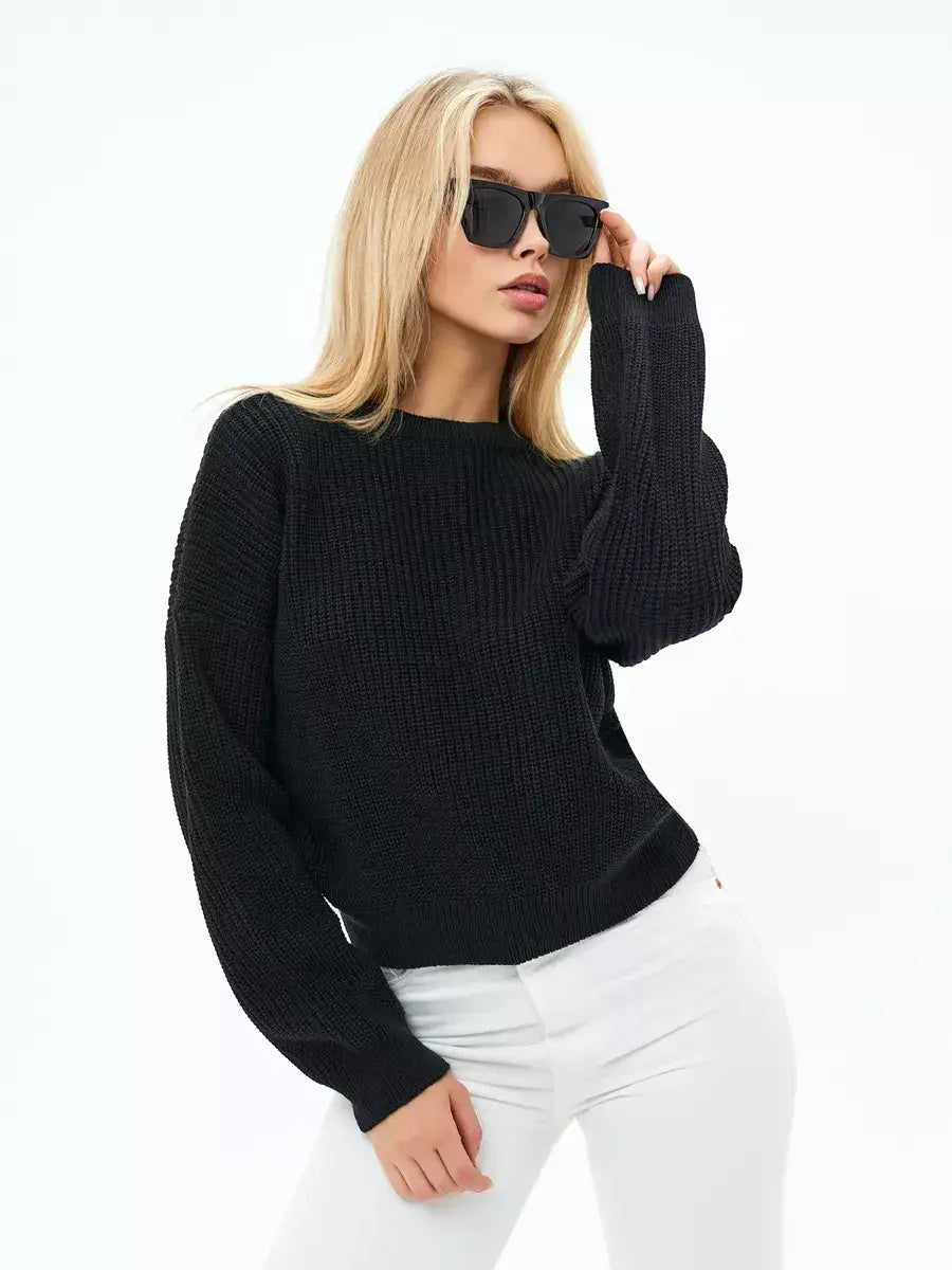 Eclipse Sweater by Lauven — Woman wearing oversized black knit sweater with sunglasses and white jeans.