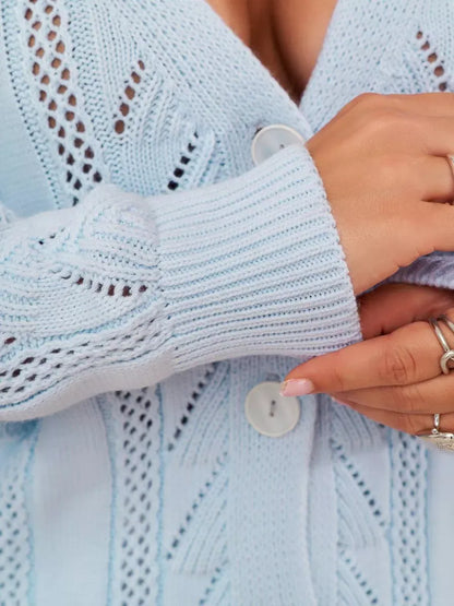 Close-up of the Elara Cardigan by Lauven featuring light blue knit, ruffles, and button closure.